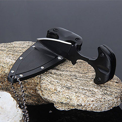 Black knife with sheath on a rock